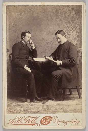 Untitled (seated portrait of two men, one with a book, the other reading a magazine)