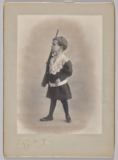 Untitled (young boy with lace collar and toy rifle)