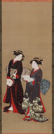 Two girls standing, one holding an open book