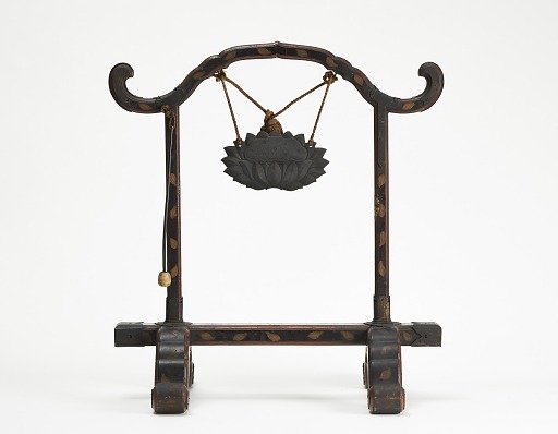Frame for a gong with a bronze gong suspended by a cord; mallet hanging
