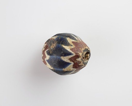 Bead, egg-shaped, with chamfered sides. Two sides chipped away