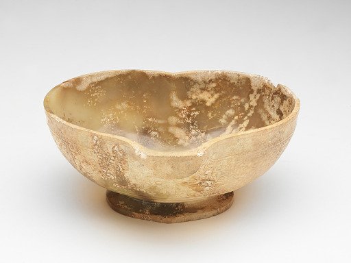 Spouted cup with mask and incised linked curls