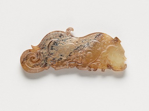 Pendant in the form of a dragon with dragon elements and raised uniform curls arranged in a grid, one of a pair
