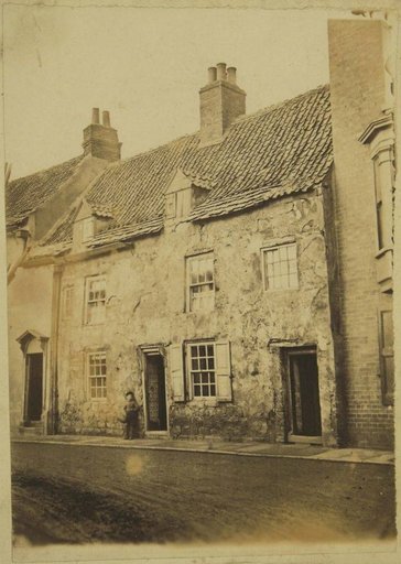 Weathered House Facade, with a Child Next to the Open Door