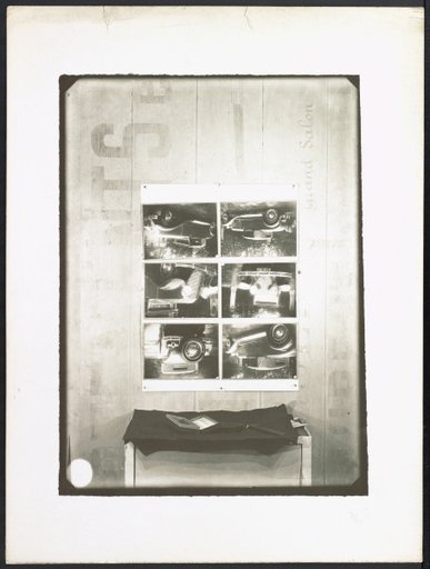 Box "L'Antidérapant" in front of a wall with photographs of Renault models