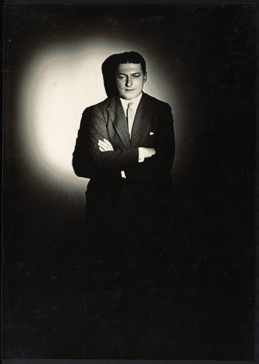 Man with crossed arms in a circle of light