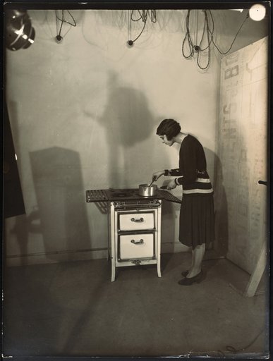 Young woman posing with the stove "Spidex" by Arthur Martin surrounded by studio equipment