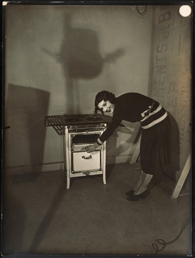 Young woman posing with the stove "Spidex" by Arthur Martin in the studio