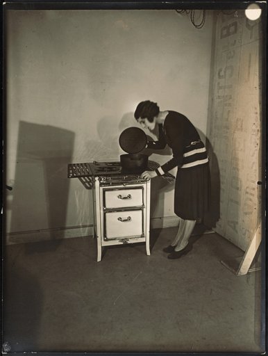 Young woman posing with the stove "Spidex" by Arthur Martin in the studio