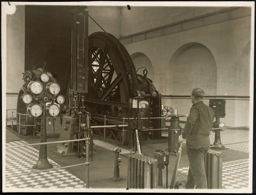 Worker at control levers of a mechanical metal installation