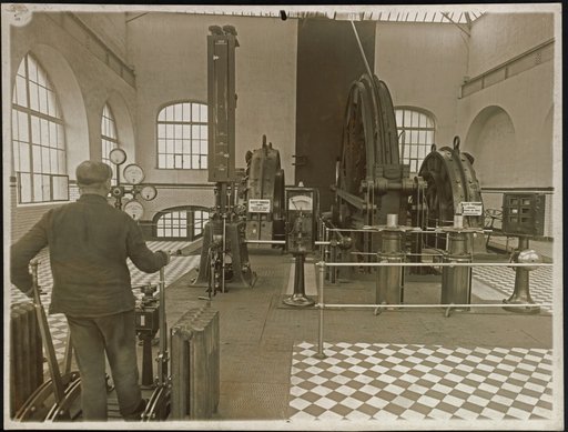 Worker at control levers of a mechanical metal installation
