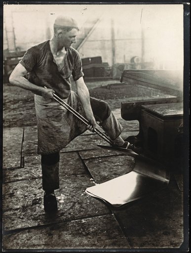 Young Man Working on a Sheet of Metal
