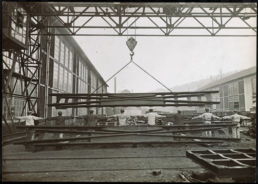 Worker Unloading a Large Metal Workpiece