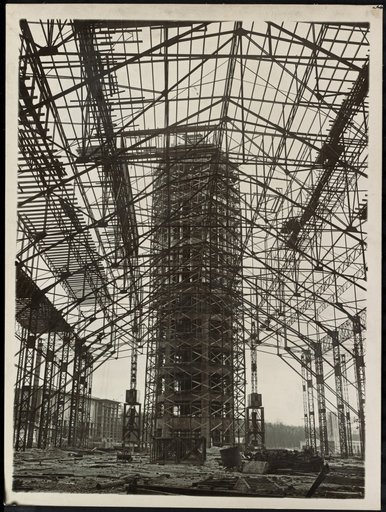 Filigree Metal Structure in Front of Tower-Like Rough Construction