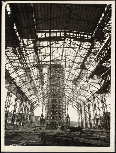 Filigree Metal Structure in Front of Tower-Like Rough Construction
