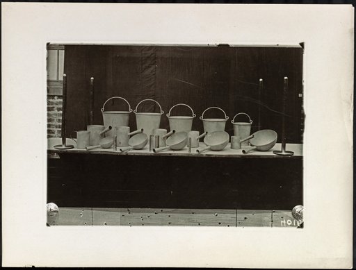 Table with Metal Pots, Pans, and Kettles