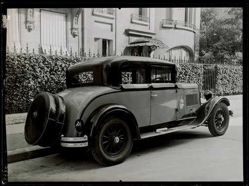 Automobile with two spare rear tires in front of a house, advertisement for zipper