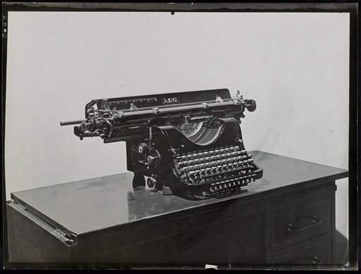 "AEG" typewriter on a small table, angled from the front