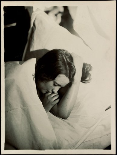 Sleeping Woman Between Pillows and Blanket