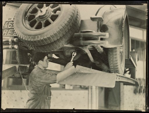 Mechanic with Wrench Standing Under Automobile
