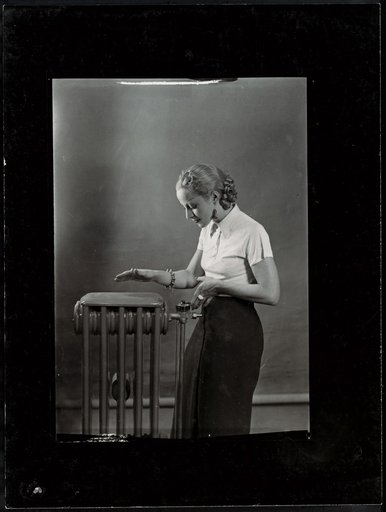 Woman posing next to a radiator, advertisement for "Gaz et Eaux"
