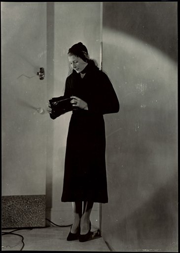 Standing Lady Displaying Leather Zipper Pouch, Photograph for "Fermeture Eclair" Calendar