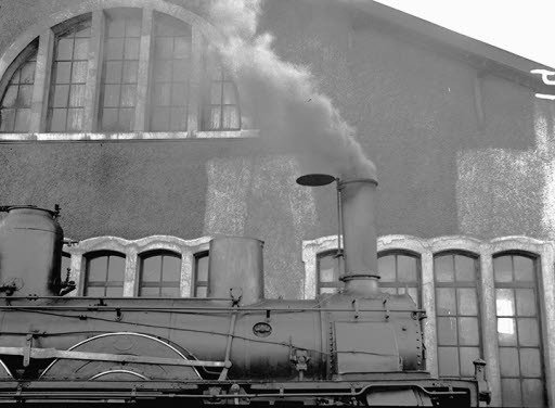 Steam locomotive in front of a building