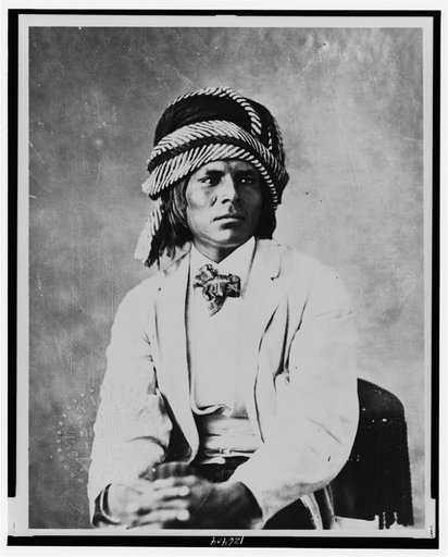Luig Moraque, a Pima man, half-length portrait, seated, facing slightly right, wearing a turban