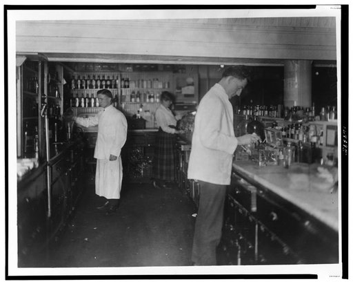 Pharmacists at People's Drug Store, 7th and E Streets, N.E., Washington, D.C., at counter preparing medications