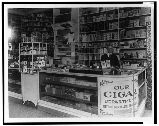 Interior of People's Drug Store, 7th and M Streets, Washington, D.C., with employee behind counter with display of candy and cigars