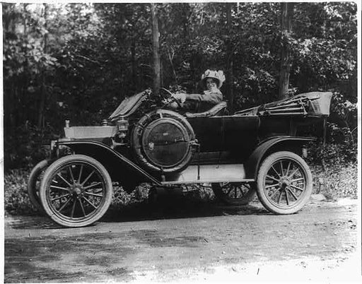 Woman seated behind steering wheel of automobile