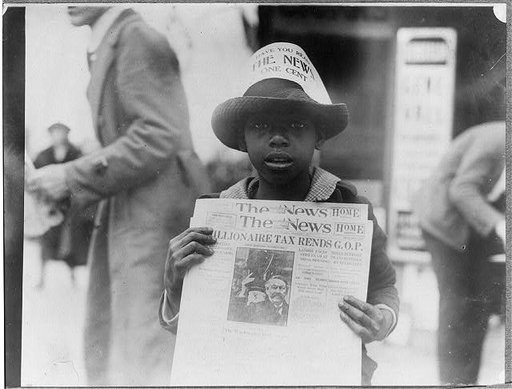 African American boy selling The Washington Daily News - sign on his hat reads, "Have you read The News? One cent" -  headline reads "Millionaire tax rends G.O.P."