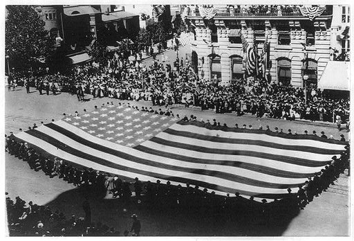 Huge flag being carried by a large group of men in a G.A.R. parade in Washington, D.C.