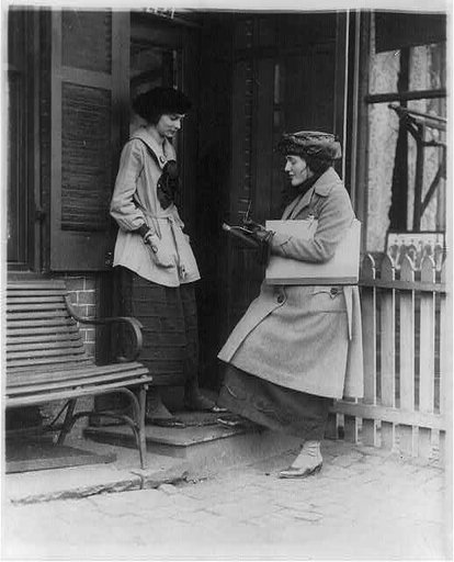 Woman taking census of another woman at door of house