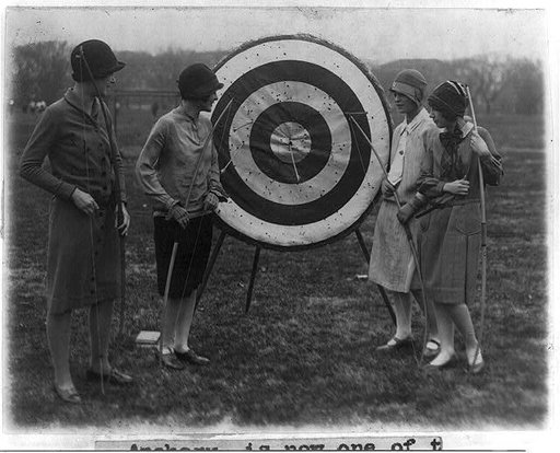 4 girls of Marjorie Webster school examining archery target - Louise Walraven, Imogene Koonce, Helyn Braskie and Helen Ackerman