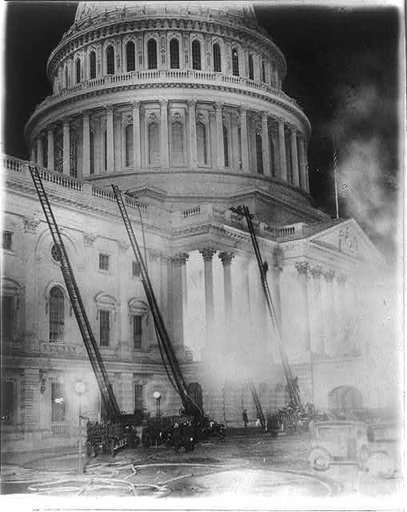 View of the U.S. Capitol during the fire which destroyed the studio of Artist Chas. Moberly & considerably damaged the House Document Room - fire engines with ladders going up the side of the Capitol
