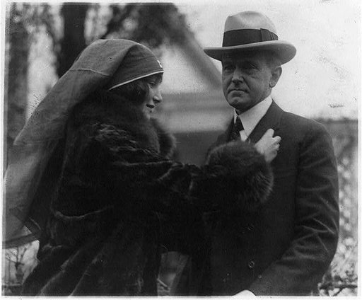 Miss Janet Moffett pinning the Red Cross button on Pres. Coolidge