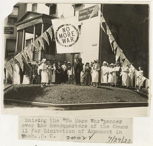 Raising the "No more war" banner over the headquarters of the Council for Limitation of Armaments in Wash., D.C.