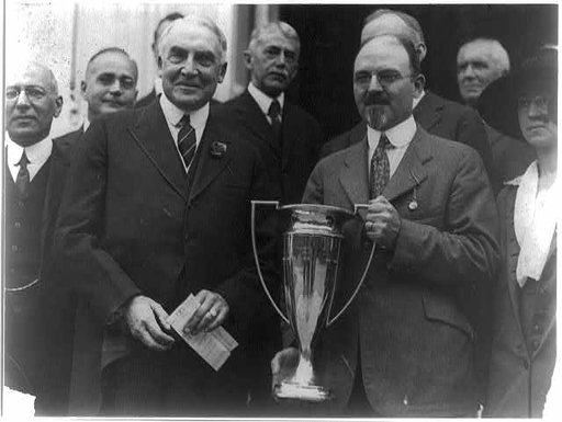 As Honorary Vice President of the National Tuberculosis Assn., President Harding presented to Dr. Frank Ballou, Supt. of Schools, the cup offered for the schools having the largest enrollment based on population