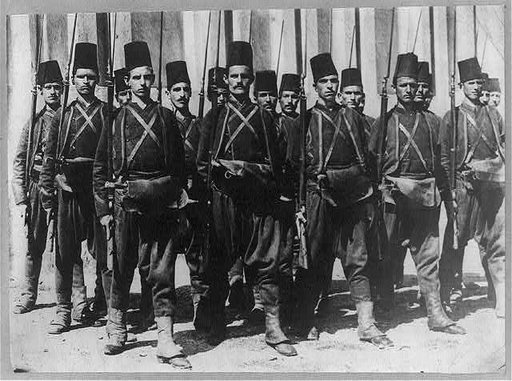18 Turkish soldiers posed, standing, with rifles
