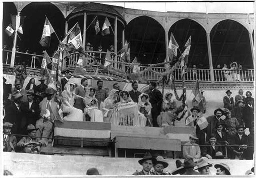 Bull fight, Mexico: guests of honor, surrounded by Mexican flags, watching bull fight