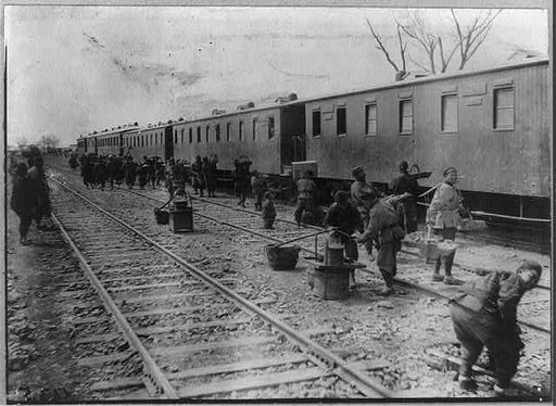 Chinese alongside railroad cars, China