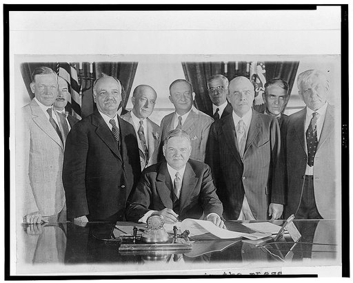 President Hoover in the prese[nce] of leaders in Congress signing the Farm Relief Bill
