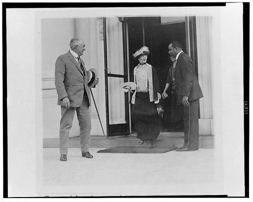 President Harding waiting patiently while Mrs. Harding bids good-by to the White House employees