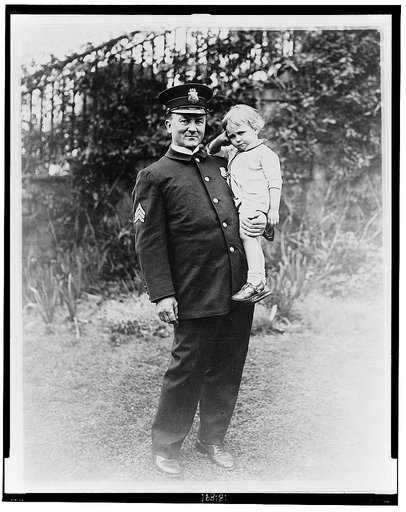 Sgt. McQuade, White House Policeman, holding a lost child