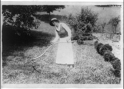 Alma Gluck cutting grass with a scythe, Aug. 3, 1917