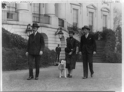 Pres. and Mrs. Calvin Coolidge, their son, John, and dog, walking outside the White House?
