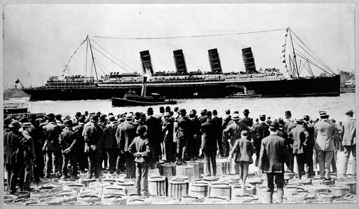 RMS Lusitania, New York City, September 1907, stern-side view, during maiden voyage, with a large crowd of men, in foreground, standing on top of barrels