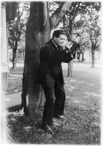 Renato Zanelle, baritone of the Metropolitan Opera, aiming a folding camera