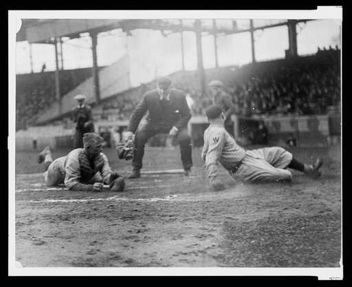 Waiting for the umpire to make the call as Washington ball player, Joe Judge, slides across home plate, the catcher, on the left, is lying on the ground with ball in hand